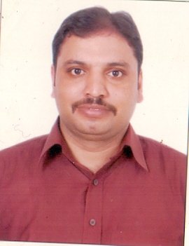 Portrait of Dr. Kapoor wearing traditional attire with academic books in background